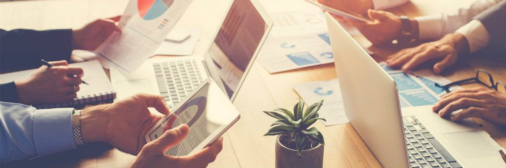 Un tavolo con diverse persone alle prese con dati e informazioni: avere molte competenze permette alle aziende di sperimentare e innovare