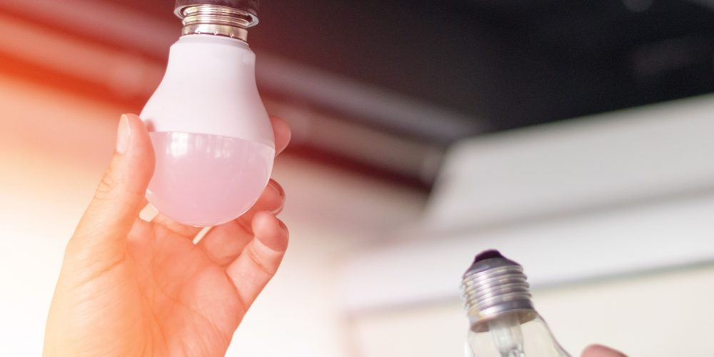 Una mano svita una lampadina: quelle alogene sono state messe al bando dall’UE