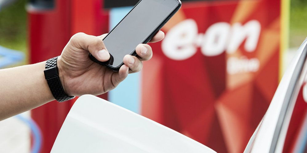 Un uomo controlla con lo smartphone la ricarica di un veicolo grazie al Progetto E.ON DriveSmart per la mobilità elettrica