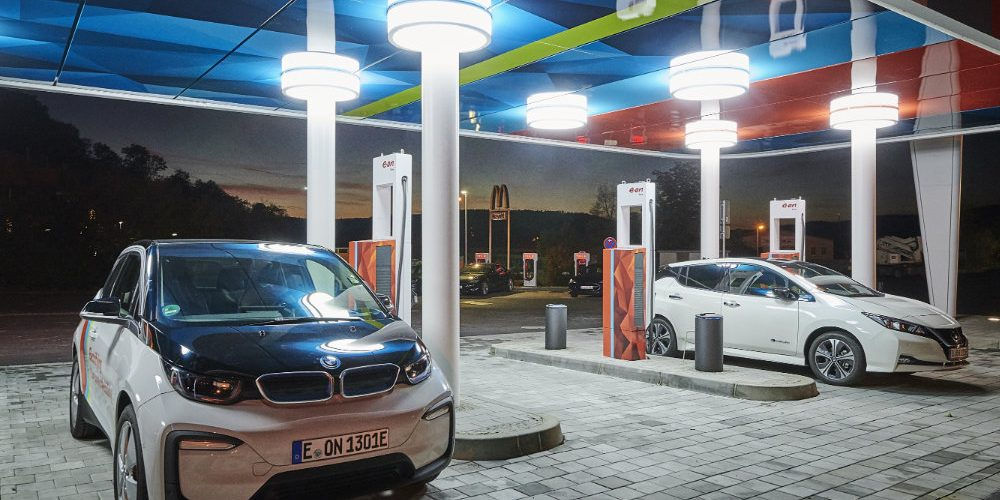 Due auto accanto a colonnine di ricarica per veicoli elettrici: la mobilità elettrica è uno strumento per la sostenibilità