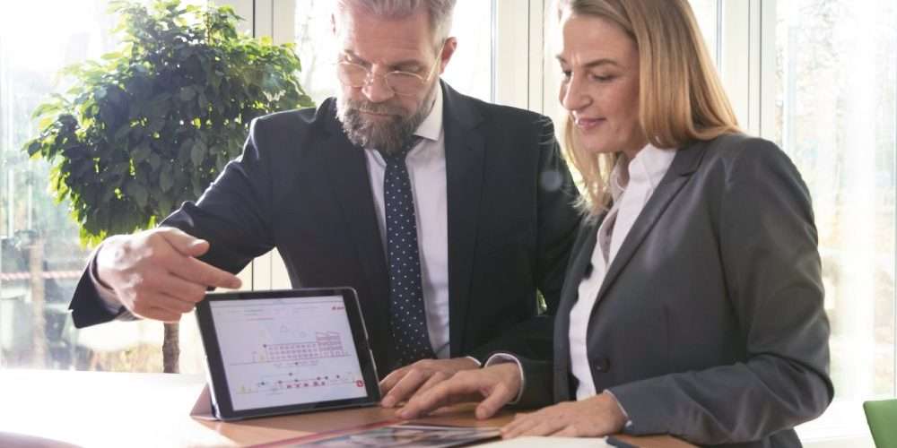 Due colleghi consultano dei dati su un tablet: la digitalizzazione è un processo che permette di gestire al meglio le aziende