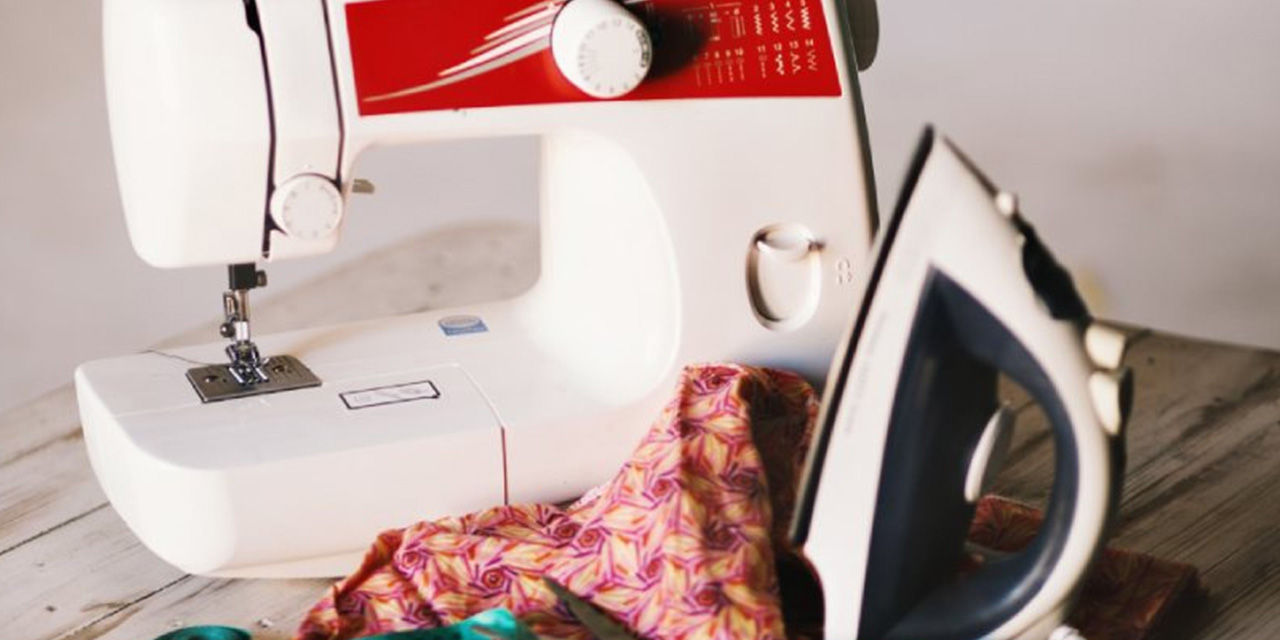 Una macchina da cucire accanto a un ferro da stiro: la moda sostenibile si basa anche sul riciclo dei vestiti