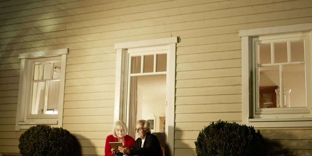 Una coppia controlla le luci smart della propria casa per un maggiore risparmio energetico