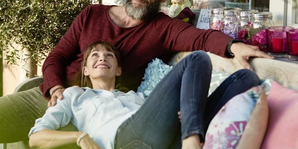 Una coppia si rilassa su un divano: anche in casa possiamo tenere piante anti inquinamento