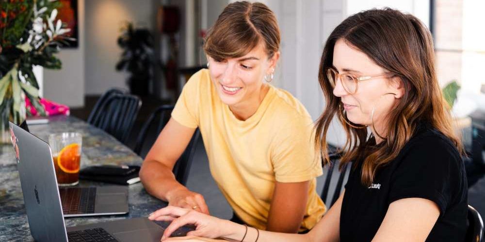 Due ragazze sorridono in smart working, una soluzione innovativa per il lavoro agile