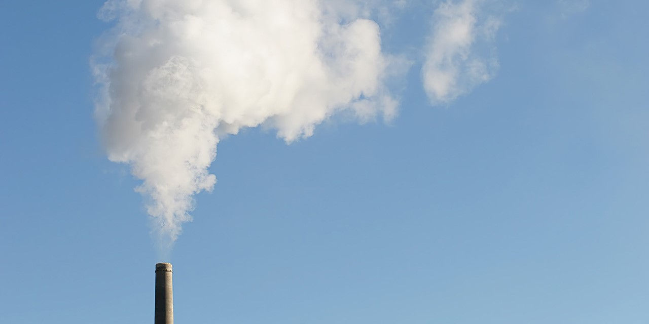 Una ciminiera immette gas di scarico, tra cui molti responsabili dell’effetto serra