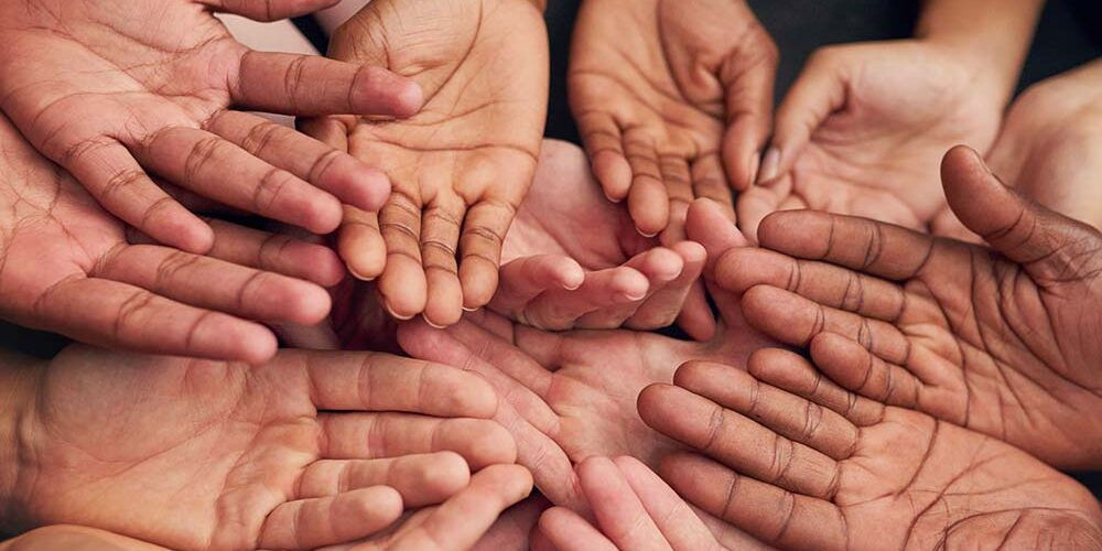 Molte mani riunite, simbolo di solidarietà e di impegno