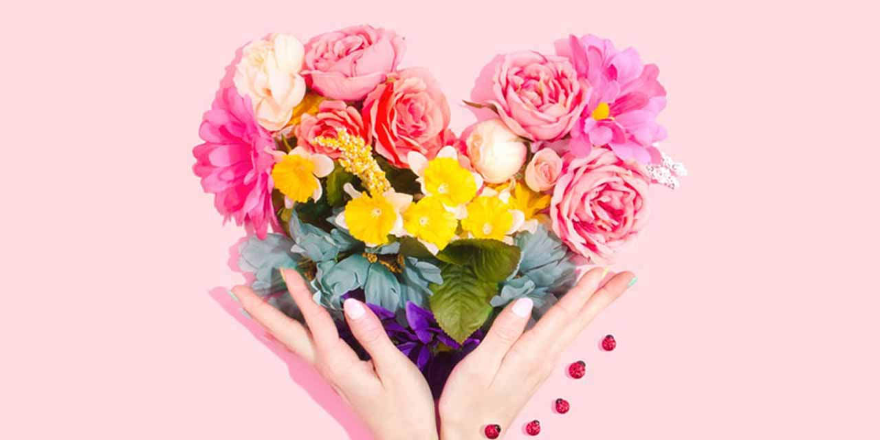 Due mani femminili sostengono un bouquet di fiori a forma di cuore: i regali sostenibili sono i più belli per S. Valentino