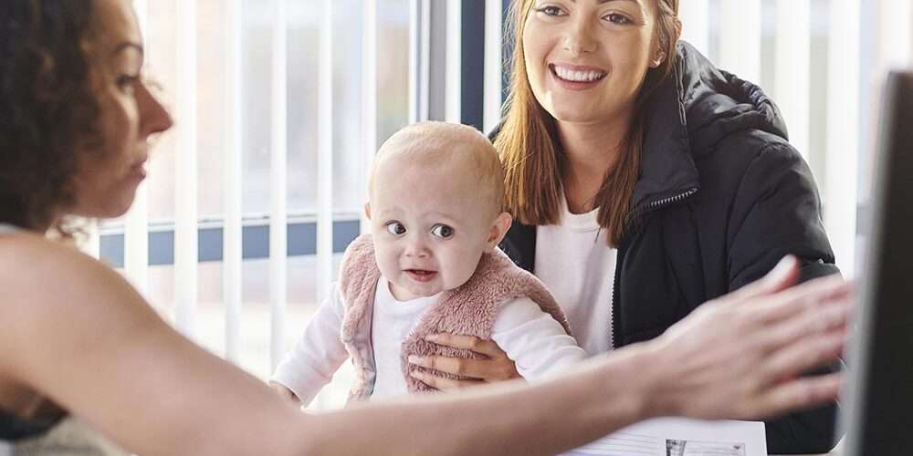 Una giovane mamma tiene in braccio una bambina: il bonus sociale è rivolto alle famiglie più fragili