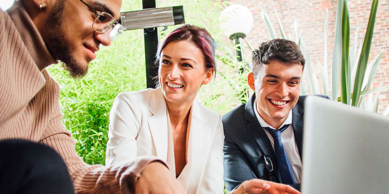 Dei giovani lavoratori sorridono davanti al computer: le professioni del futuro sono sempre più green