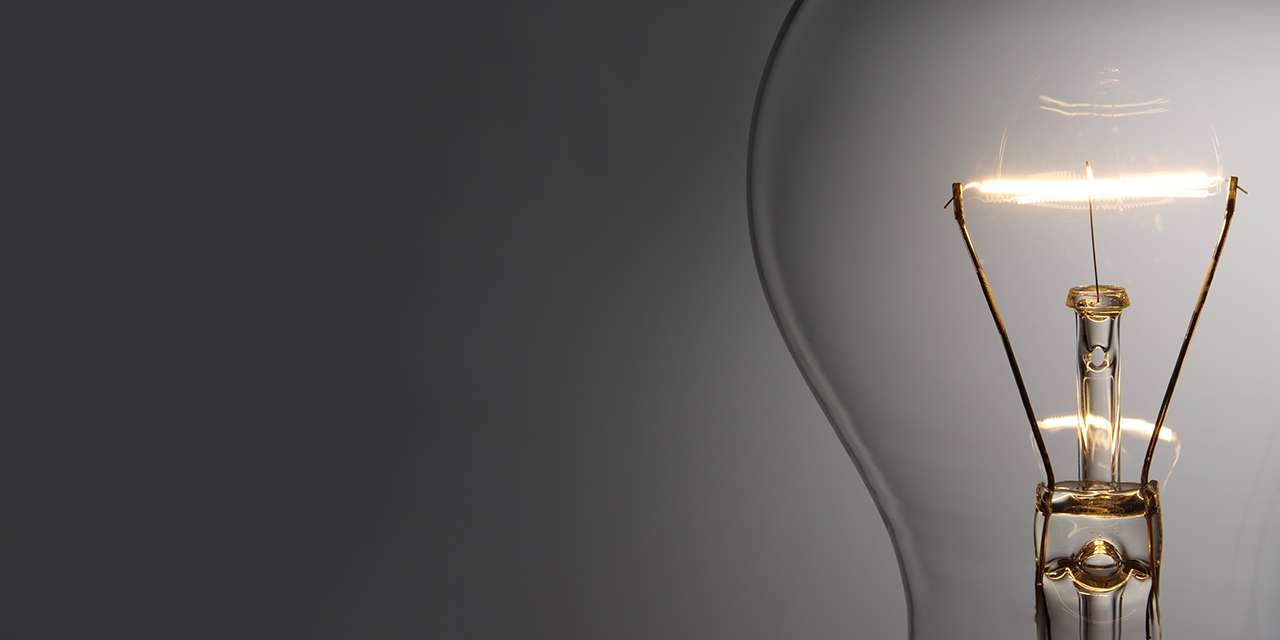 Primo piano di una lampadina accesa: l’elettricità ha tanti padri e tante madri nella scienza