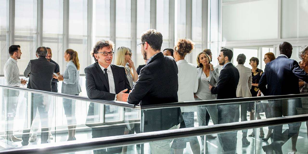 Amministratori si scambiano opinioni durante una pausa a un evento per condomìni