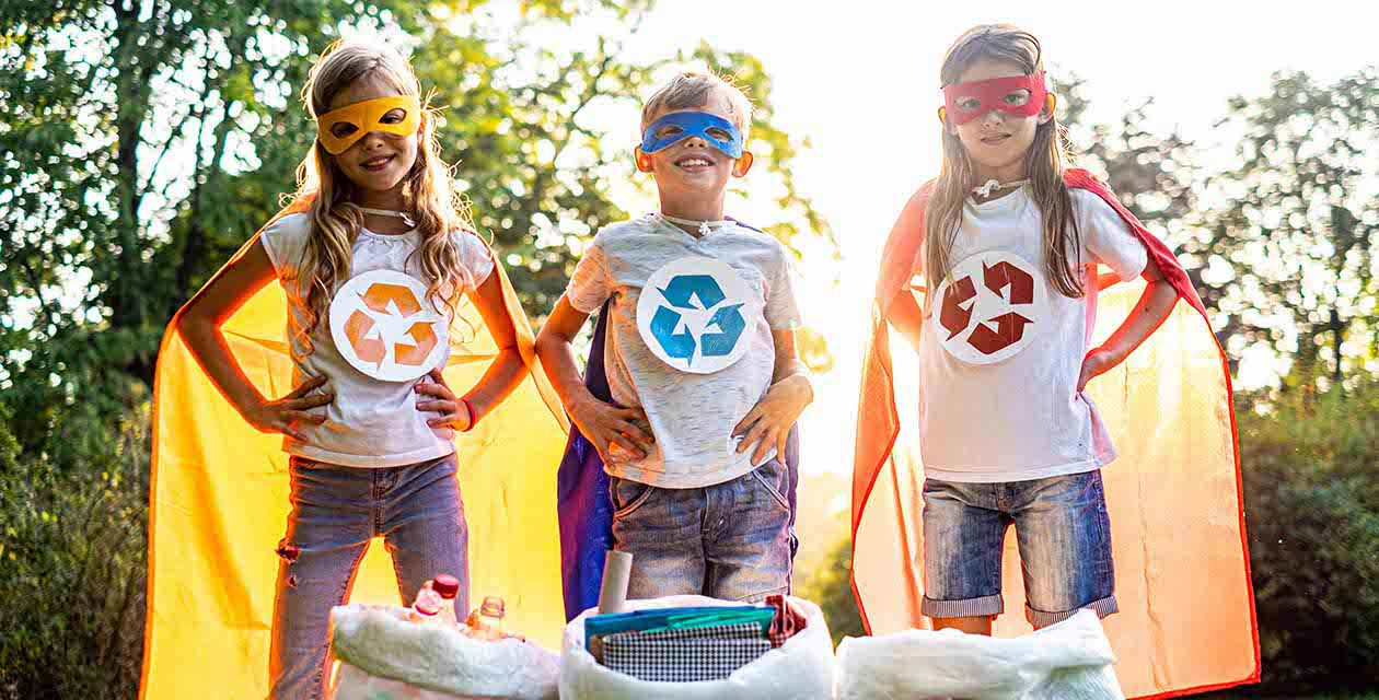 Tre bambini vestiti da supereroi promuovono la raccolta differenziata e il riciclo