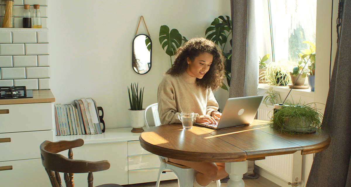 Una ragazza lavora al computer in un soggiorno: i nostri comportamenti sono decisivi per ridurre l’inquinamento digitale
