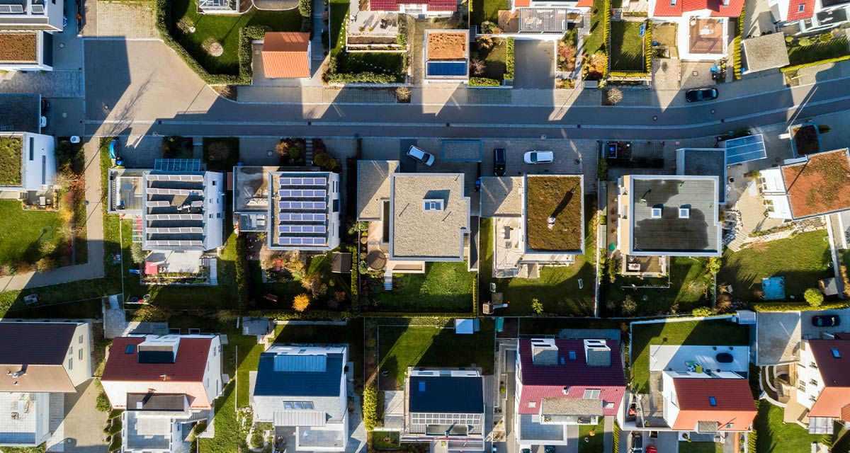 Una panoramica sui tetti di un centro abitato, con diversi edifici che presentano pannelli fotovoltaici