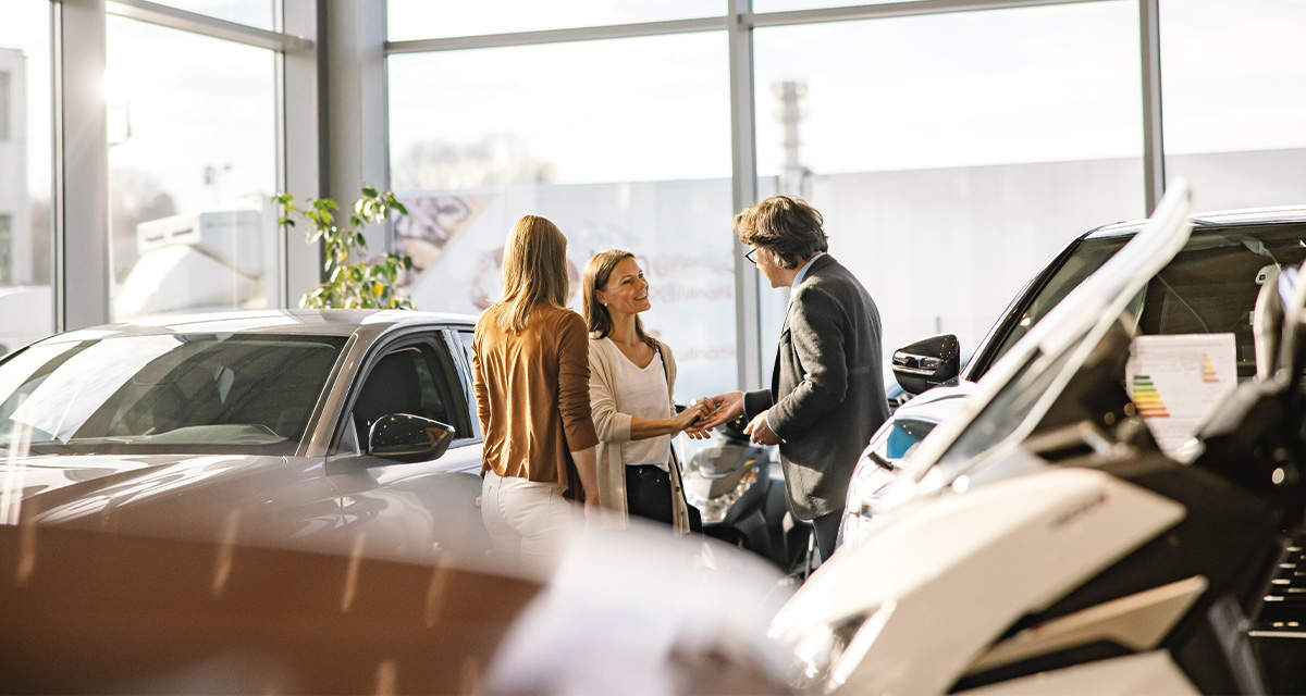 Un gruppo di persone in un concessionario di auto elettriche, mezzi su cui esistono ancora falsi miti e fake news