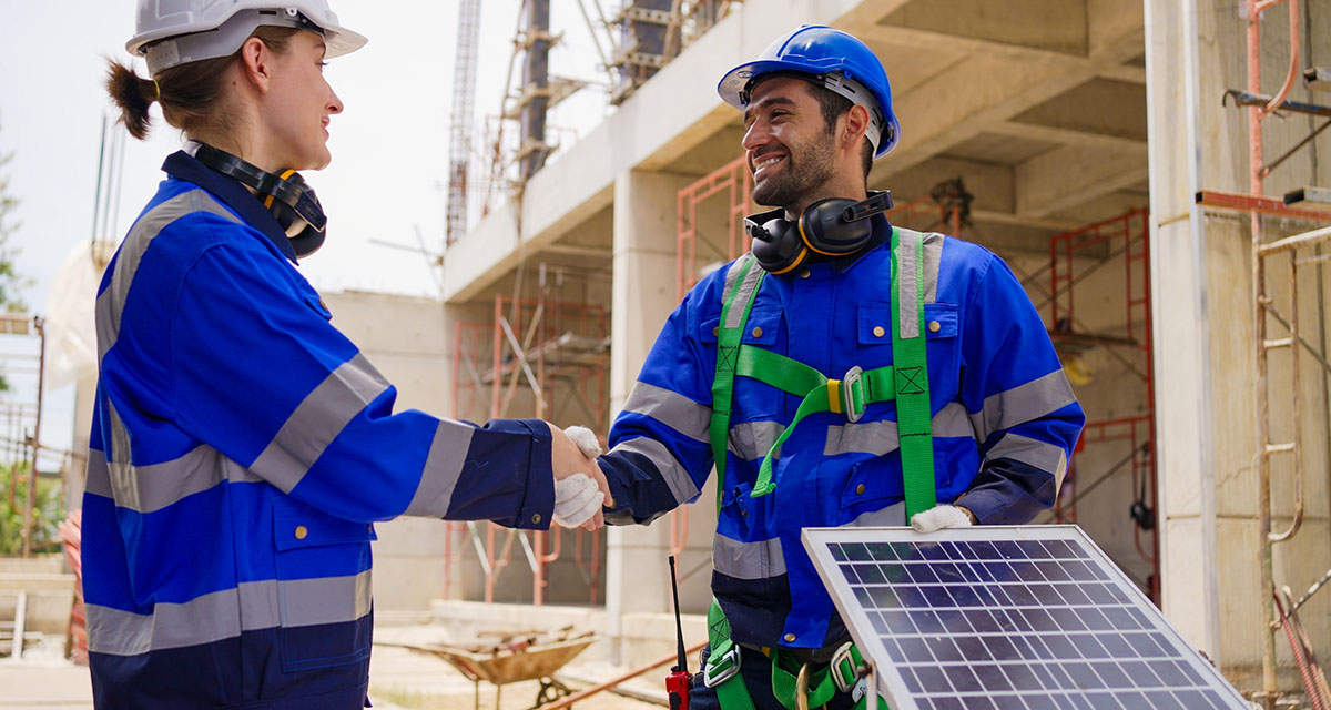 Un tecnico stringe la mano a una cliente, mostrando un pannello fotovoltaico