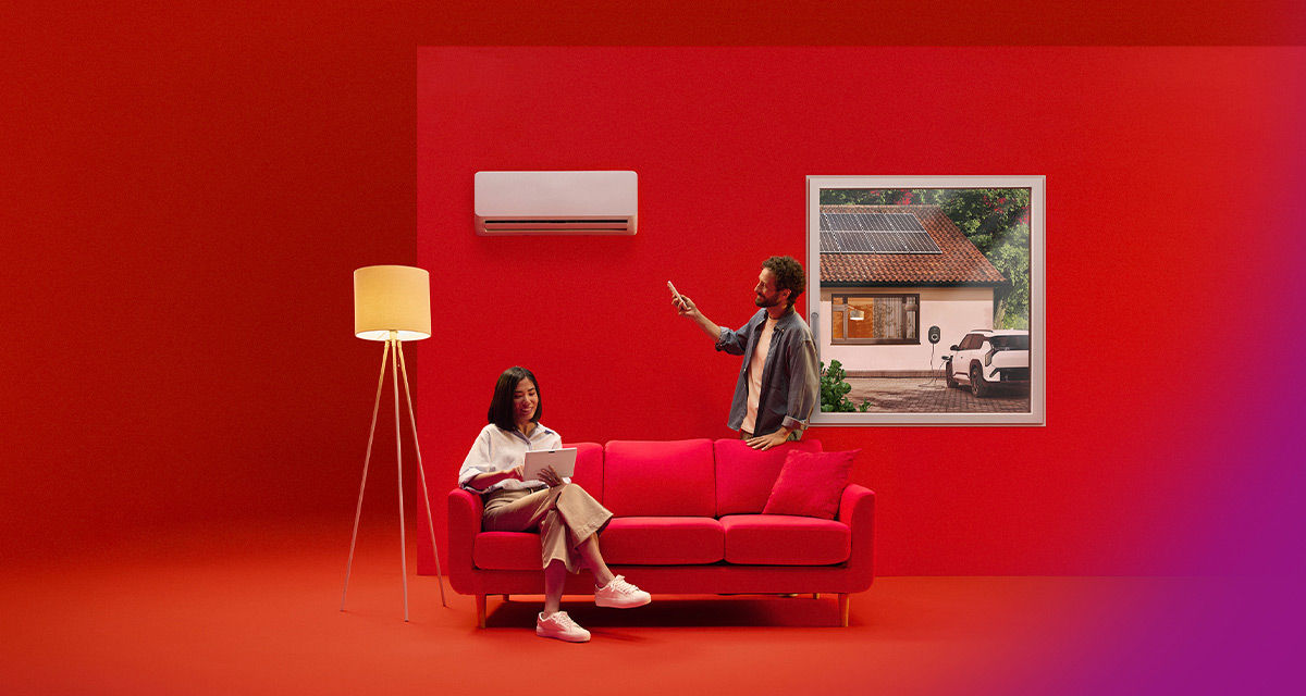 Una giovane coppia, in soggiorno, alle prese con illuminazione e climatizzazione