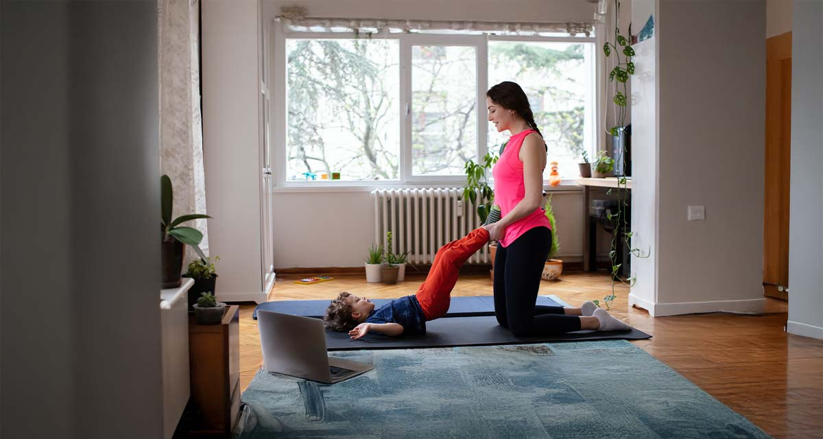 Una mamma fa ginnastica con il figlio in un soggiorno confortevole grazie anche alle valvole termostatiche sul radiatore