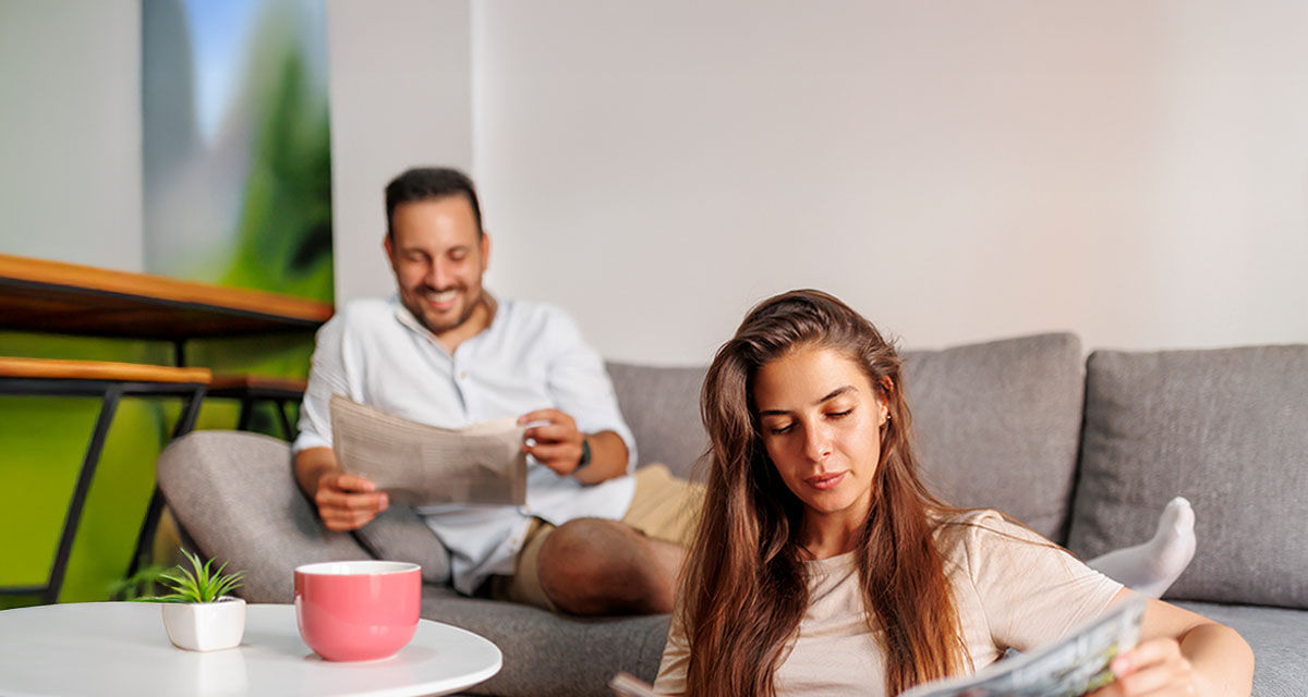Una coppia legge rilassata in soggiorno: informarsi è il primo passo per conoscere le fake news sull'energia